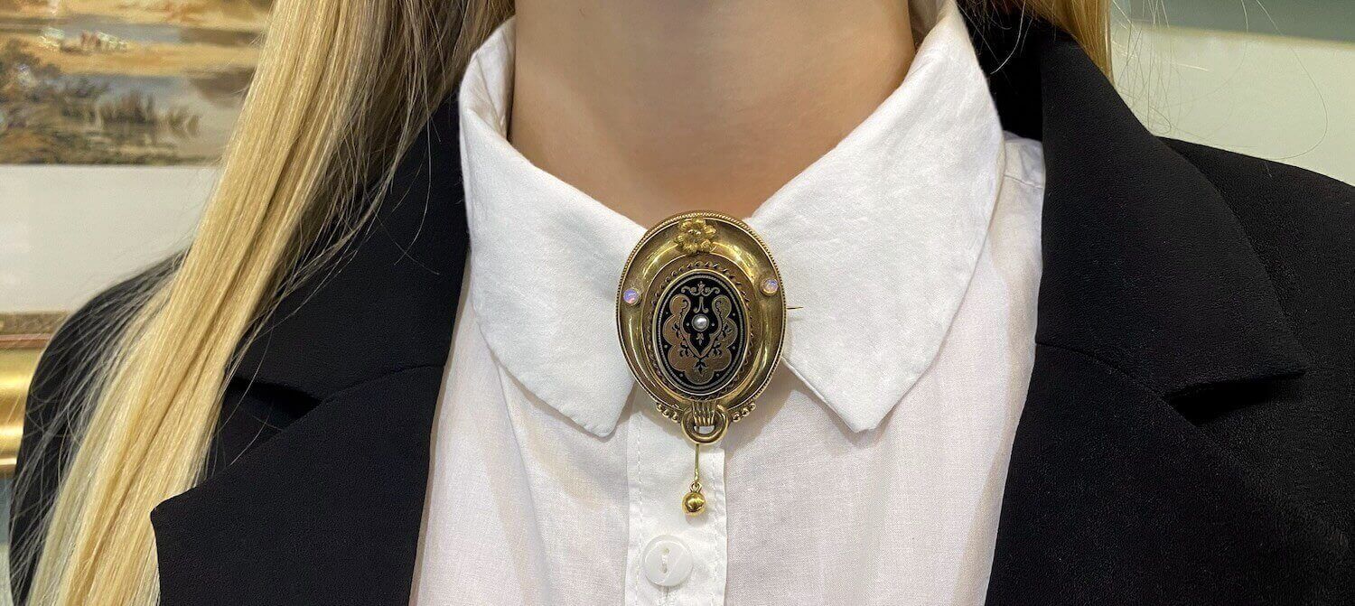 Zlatá brož připnutá na límci